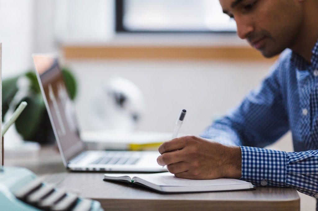 Writer with laptop and notebook